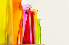 Row Of Colorful Glass Vases Jars On A Shelf With A White Background For Copy
