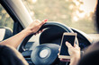 © LumineImages - Close-up of woman texting on mobile phone while driving a car.