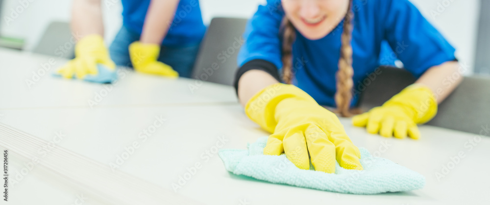 Close-up of cleaning team working in an office - obrazy, fototapety, plakaty 