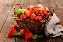 Wicker Basket With Juicy Strawberry On Wood Background