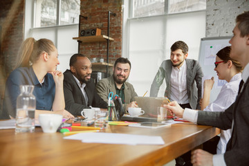 One family. Group of young business professionals having a meeting. Diverse group of coworkers discuss new decisions, plans, results, strategy. Creativity, workplace, business, finance, teamwork.