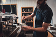 Barista preparing cappuccino on espresso machine for customer in coffee shop.