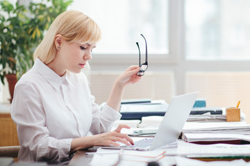 Woman in office working, reading a document