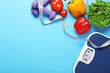 © Pixel-Shot - Different healthy food with measuring tape, scales and dumbbells on color background. Diet concept