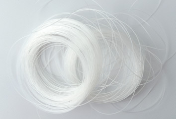 Closeup of tangled white fishing line on the white surface