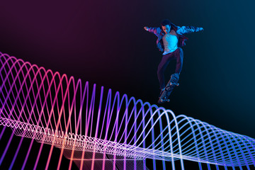 Caucasian young skateboarder riding on dark neon lighted line background. Training in action and motion on colorful waves. Concept of hobby, healthy lifestyle, youth, action, movement, modern style.