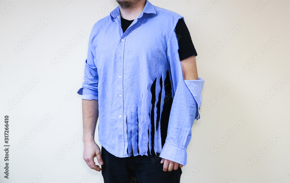 Ripped shirt. Man in old clothes which need repairing and sewing. Stock Photo Adobe Stock