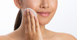 © Prostock-studio - Girl applying lotion using cotton pad, white background