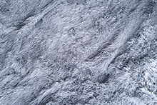 Grey Sheepskin Rug Background. Close Up Shaggy Fur Textured Background.