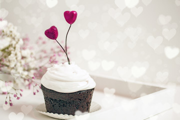 Canvas Print - Valentines day cupcake. Cupcake with white cream and red  hearts on a white background, bokeh effect, copy space. St. Valentine's Day card