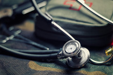 Stethoscope Lies On The Uniform Of A US Soldier. The Concept Of Health Care, Military Insurance, State Care. Top View.