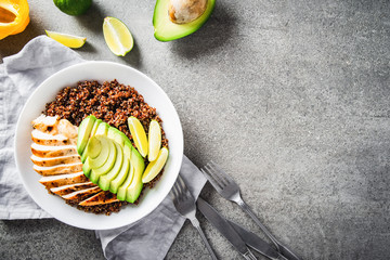 Wall Mural - Healthy dish plate with quinoa, chicken, avocado, lime on concrete background top view. Food and health. Superfood meal.