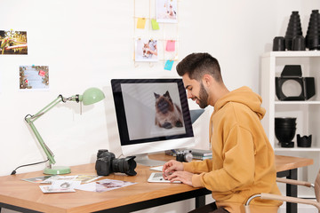 Wall Mural - Professional photographer working at table in office