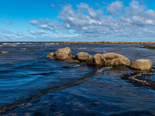 landscape with rocky sea shore, white clouds in the sky