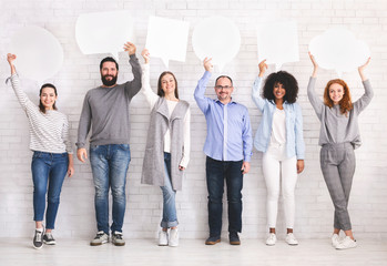 Diverse people holding empty speech bubbles above their heads, free space