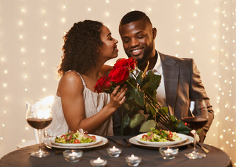 Wall Mural - Thankful black lady holding bunch of roses, kissing her boyfriend