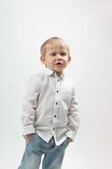 Portrait of a stylish and fashionable charismatic boy in a white shirt on a light background tells something.