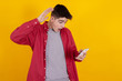 amazed young teenager boy looking at mobile phone with surprise isolated on color background
