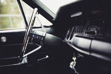 Closeup Shot Of A Muscle Car Steering Wheel On A Blurred Background