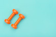 © Augustas Cetkauskas - Orange dumbbells isolated on green background