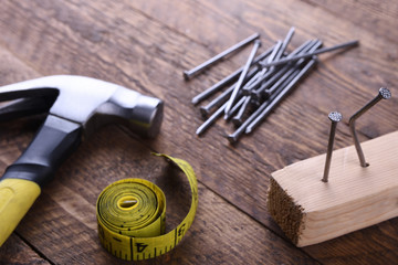 Sticker - Hammer iron,centimeter tape and nails on wooden background