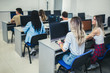 © Mediteraneo - College students sitting in a classroom, using computers during class.