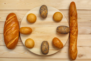 French baguette, loaf and buns on a wooden background