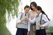 © Blue Jean Images - Students showing teacher smartphone