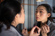 © Juan Alberto Ruiz/ADDICTIVE STOCK - Asian woman applying eyeliner in front of mirror