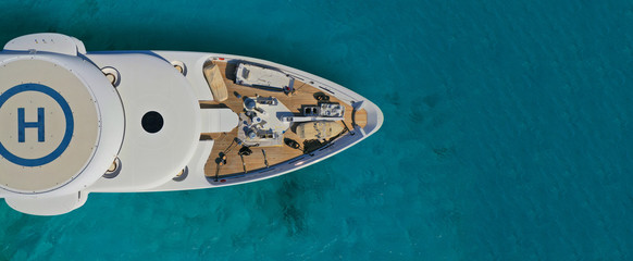  Aerial drone ultra wide photo of mega yacht nose docked in tropical exotic island bay with turquoise clear sea