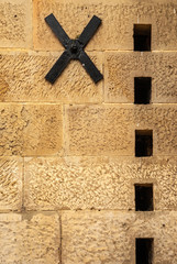 Richmond, Tasmania, Australia - December 13, 2009: Closeup of heavy metal black wall anchor in brown stone wall with line of rectangular holes at historic gaol building.