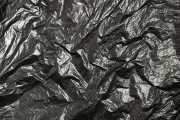 Surface of black wrinkled plastic bag.