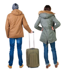 Poster - young couple in winter jacket traveling with suitcas.