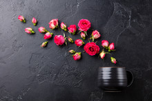 Tea Cup With Fresh Roses Flowers On Black Stone Background. Top View. Copy Space.