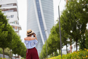 Girl in a hat photographs the modern building