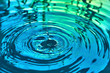 Raindrops fall on the surface of the water. The circles from the raindrops on the water surface. Abstract color background of circles on the water and falling drops.