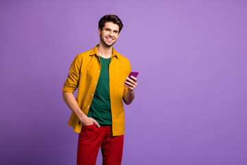 Aufkleber - Photo of cheerful positive handsome man smiling toothily holding telephone having just been purchased satisfied isolated violet pastel color background