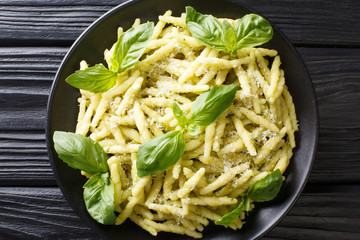 Wall Mural - Pasta trofie recipe with basil pesto and parmesan close-up in a plate. Horizontal top view