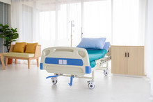 Empty Bed In A Hospital Room.blue And White Hospital Bed On White Background. Patient Room And Insurance Concept.