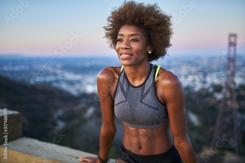Fotografía fit african woman woman resting on bench at runyon canyon shortly after sunset