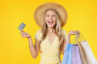 © InsideCreativeHouse - Excited screaming young woman holding shopping bags and credit card standing isolated over yellow background