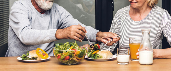 Senior couple enjoy eating  healthy breakfast together in the kitchen.Retirement couple concept