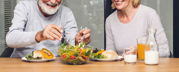 Senior couple enjoy eating  healthy breakfast together in the kitchen.Retirement couple concept