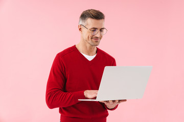 Wall Mural - Portrait of handsome man wearing eyeglasses holding laptop computer