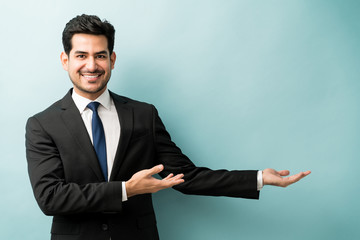 Wall Mural - Happy Businessman Doing Advertisement In Studio