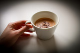 Fototapeta Mapy - hand holding cup of coffee on black background