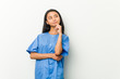 © Asier - Young asian nurse woman looking sideways with doubtful and skeptical expression.