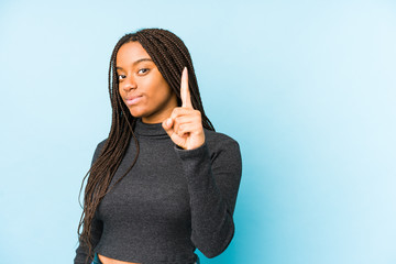 Young african american woman isolated on blue background showing number one with finger.