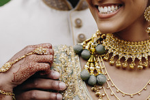 Front View Of Indian Bride's Smile And Traditional Wedding Accessories, Hands Colored With Henna
