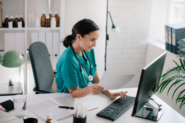 Young beautiful doctor in medical office. Female doctor working on analysis. 